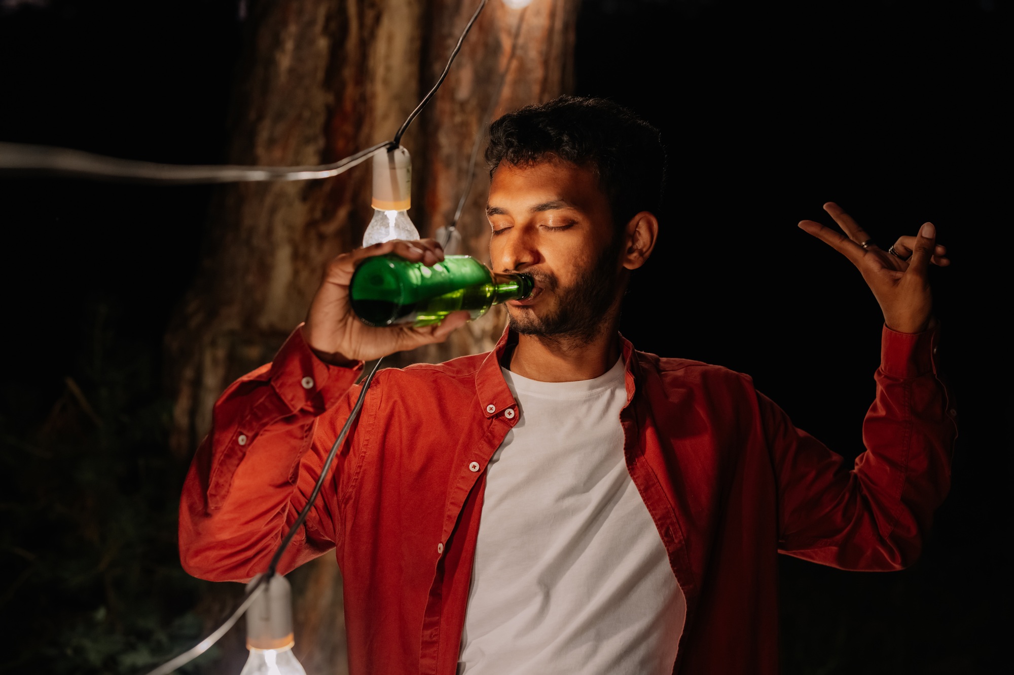 Indian man drinking beer, drinking a lot of beer at a party with friends, addicted to alcohol